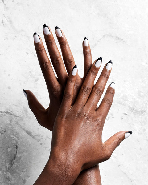 Overhead shot of two hands with white and black painted nails